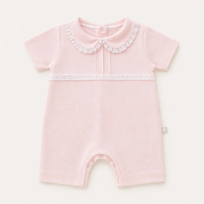 Macacão de bebê rosa claro com gola Peter Pan e detalhes em renda, manga curta.