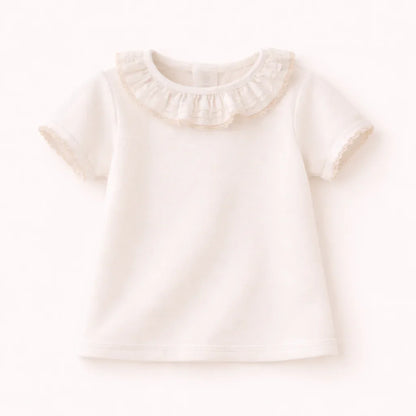 Camiseta de bebê branca com babados na gola, manga curta, feita em Portugal, confortável.