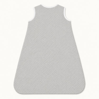 Saco de dormir para bebé em cinza com textura acolchoada e bordas brancas, ideal para recém-nascidos