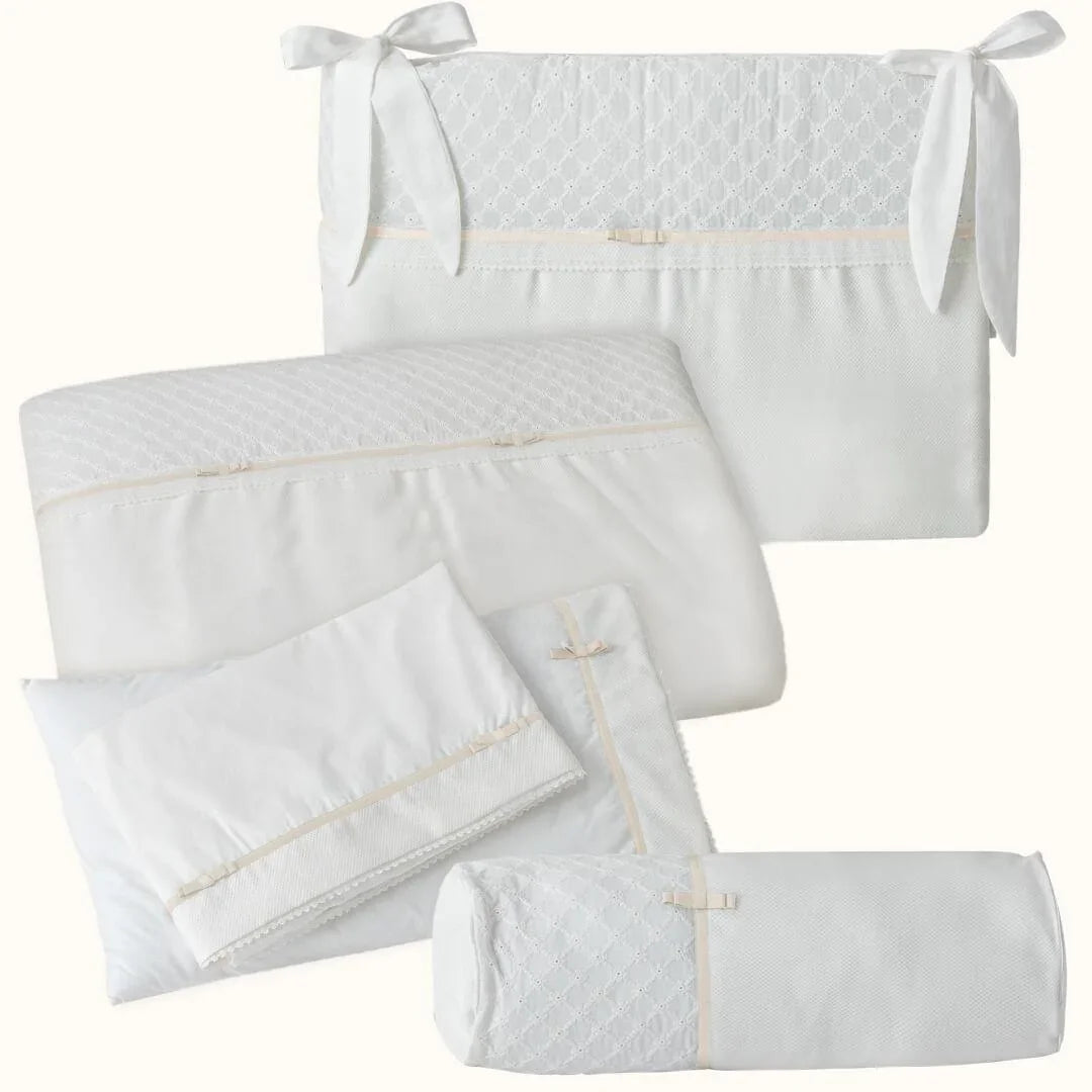 Jogo de roupa de berço bege e branco com laços, ideal para recém-nascido, delicado e elegante.