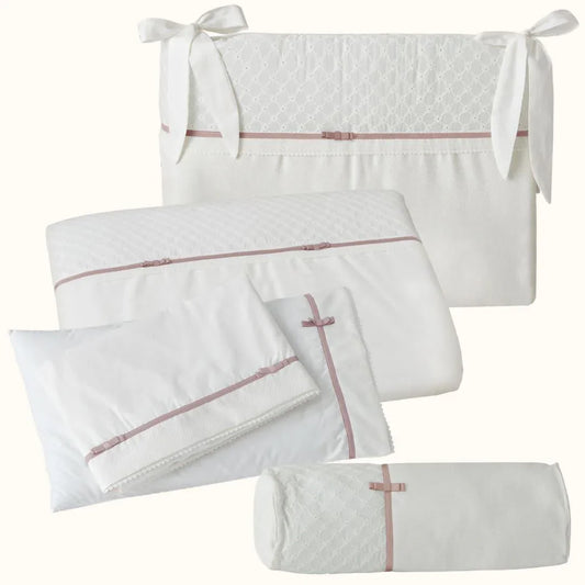Enxoval de berço branco com detalhes rosa velho, laços e textura delicada para bebê