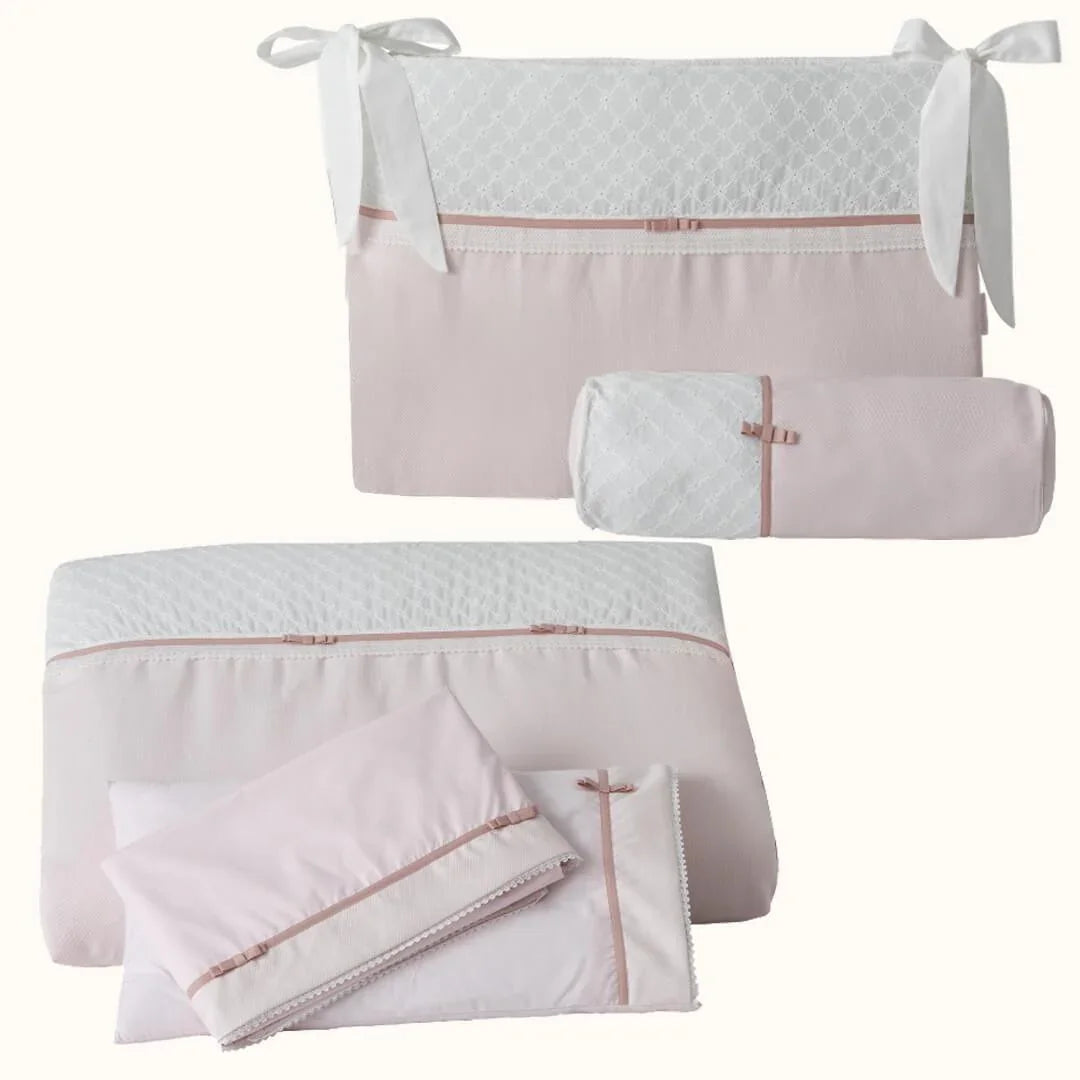 Enxoval de berço rosa para bebé, inclui almofada, rolo, edredom e protetor com detalhes rendados.