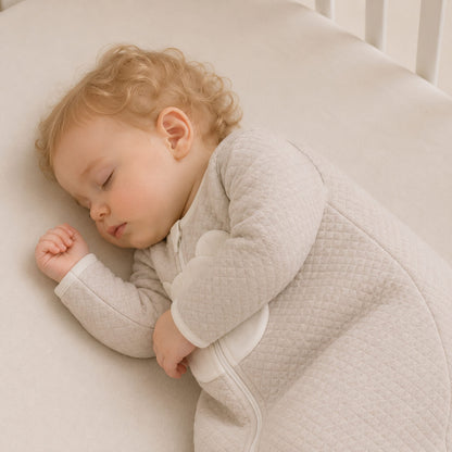 Bebé dormindo confortavelmente num saco de dormir com mangas TOG 2,5