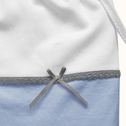 Saquinho para roupa de bebê azul e branco com detalhe de laço cinza e renda decorativa.