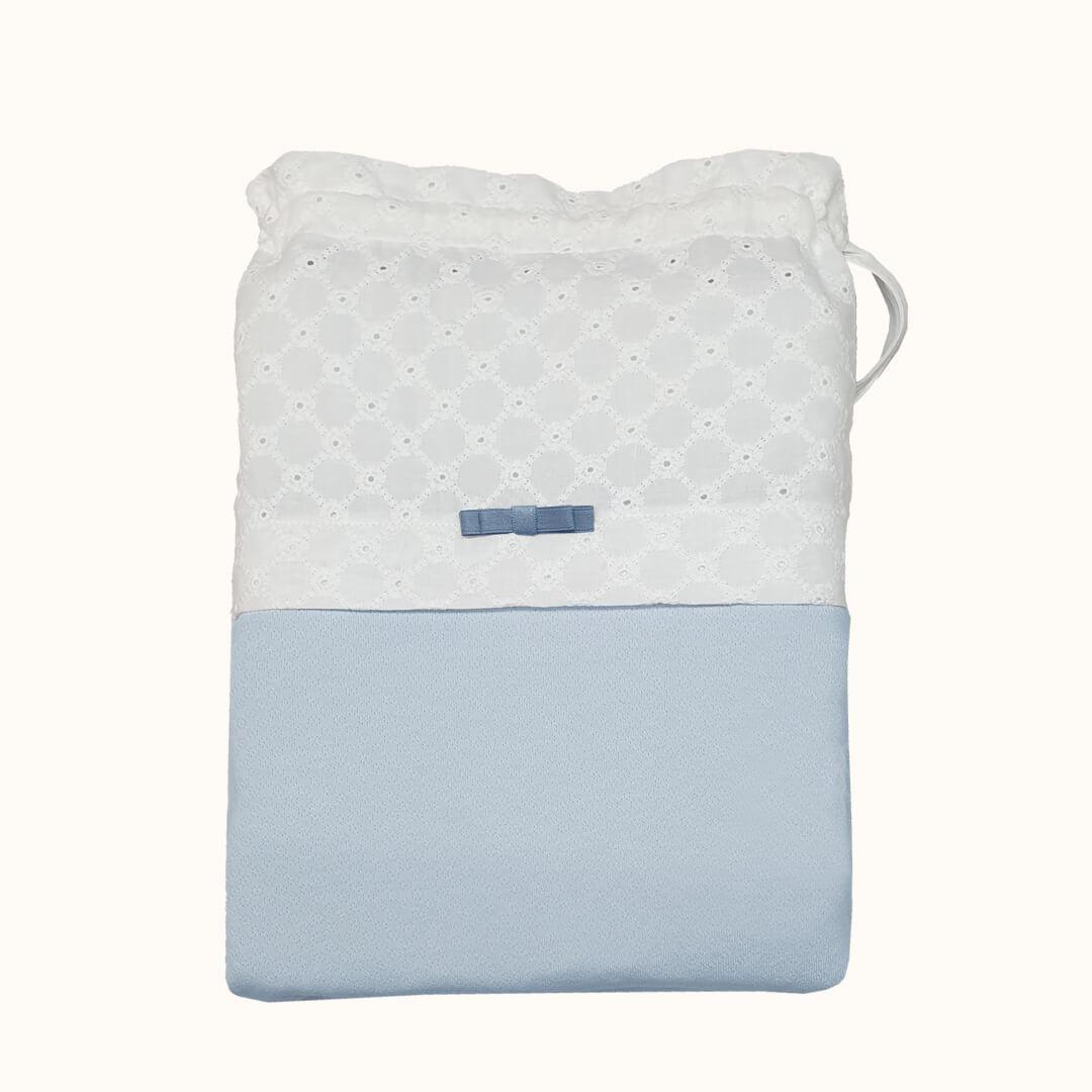 Saquinho para roupa de bebé em tecido branco com renda e detalhe de laço azul claro