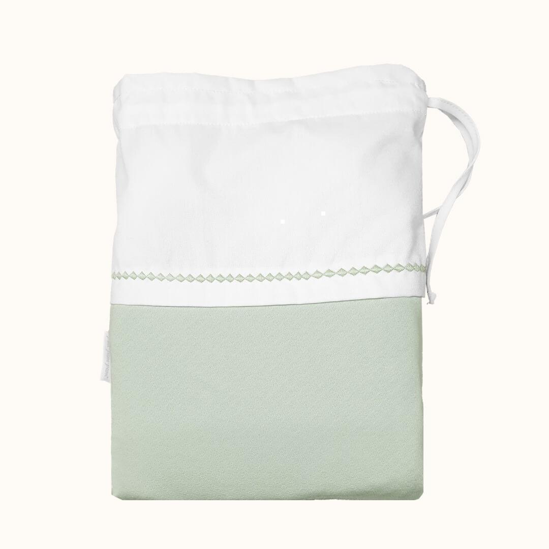 Saquinho para roupa de bebê em tecido branco e verde claro, com cordão para fechar.